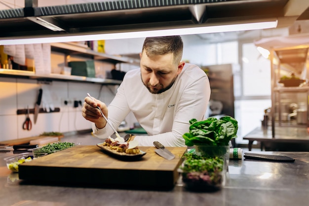 Il capo chef serve stuzzichini tartine o panini che aggiungono il tocco finale al piatto prima che venga servito agli ospiti del ristorante