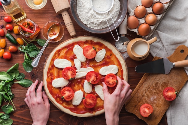 Il capo passo dopo passo prepara una pizza margarita. Ingredienti per impasto e pizza