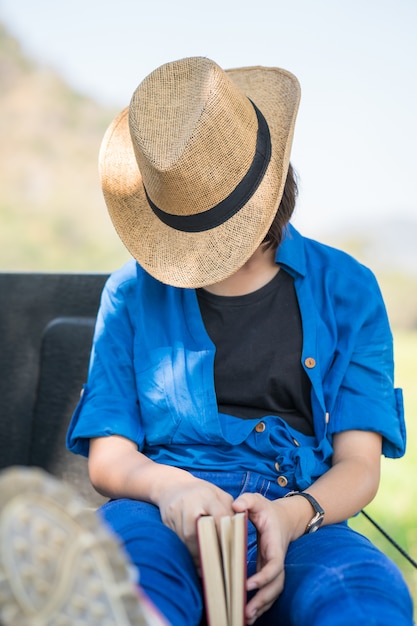 Il cappello di usura della donna si siede il sonno in campagna