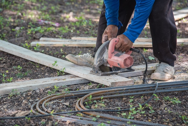 Il carpentiere scheggia da una sega circolare al cantiere