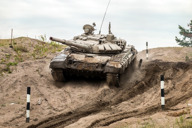 Il carro armato da battaglia esegue esercizi per guidare attrezzature militari su un campo di carri armati