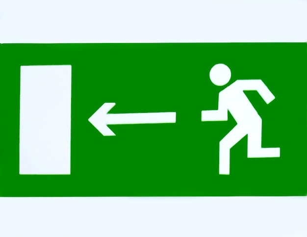 Il cartello mostra la direzione dell'uscita di evacuazione su uno sfondo bianco in verde