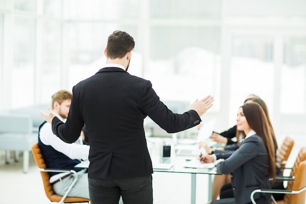 Il CEO parla al team aziendale dell'officina in un ufficio moderno.