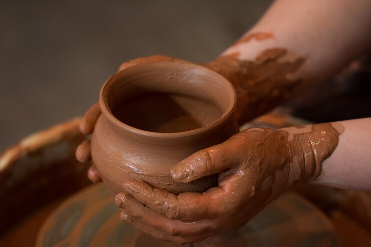 Foto il ceramista tiene in mano un vaso di terracotta già pronto