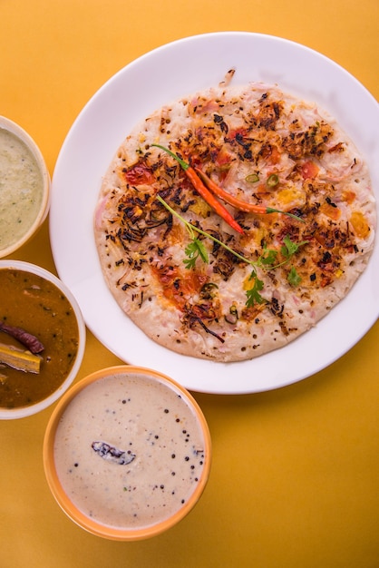 Il cibo dell'India meridionale Uttapam o ooththappam o Uthappa è un piatto simile alla dosa preparato cuocendo gli ingredienti in una pastella, servito con chutney di cocco, chutney verde e sambar