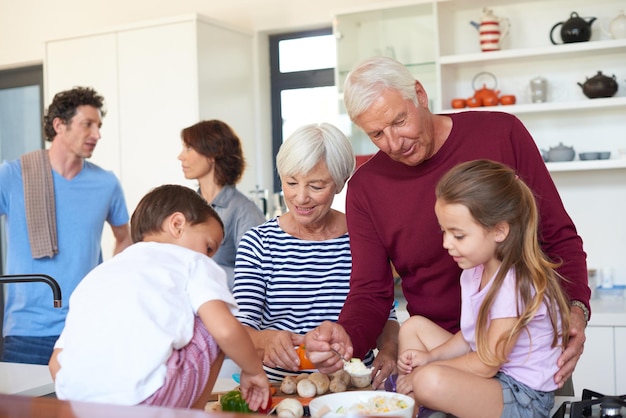 Il cibo è al centro di questa famiglia Foto dei nonni che preparano la cena con i nipoti in cucina