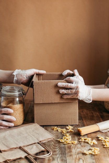 Il cibo viene raccolto in una scatola di donazione su un tavolo di legno.