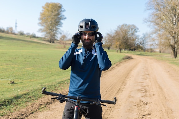 Il ciclista in pantaloni e giacca in pile su una bici moderna con una forcella a sospensione pneumatica guida fuoristrada