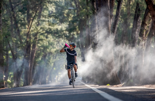 Il ciclista sta bevendo acqua dalla bottiglia sportiva