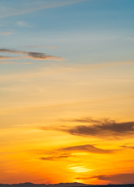 Il cielo al tramonto si rannuvola il fondo verticale con la luce del sole arancione la sera