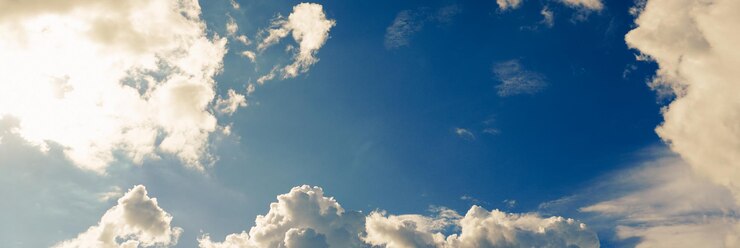 Foto il cielo azzurro con nuvole e sole splende luminoso durante il giorno in estate