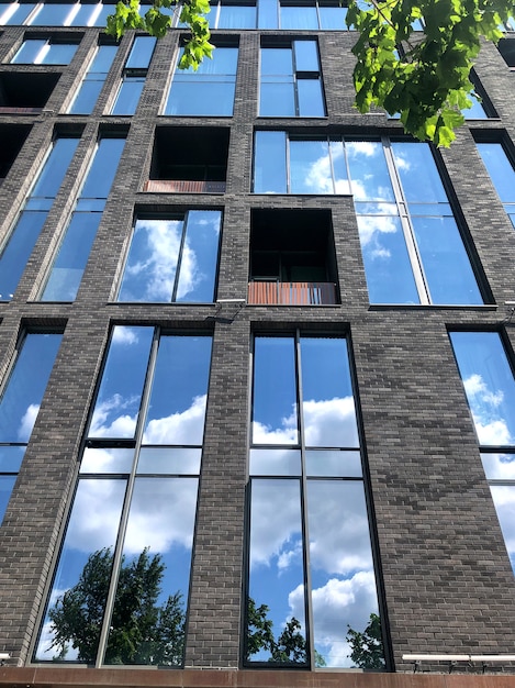 Il cielo blu si riflette nei vetri di un moderno edificio a soppalco