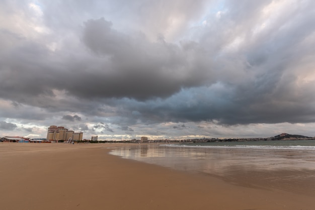 Il cielo è coperto di nuvole scure e la spiaggia è nuvolosa