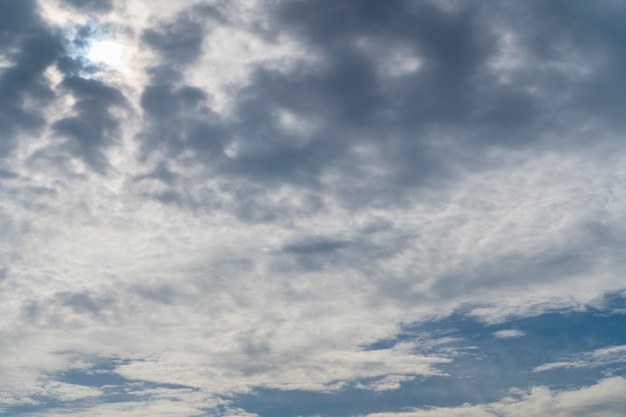 Il cielo è pieno di nuvole che galleggiano intorno sia piccole che grandi, il sole splende brillantemente Le nuvole di pioggia stanno arrivando