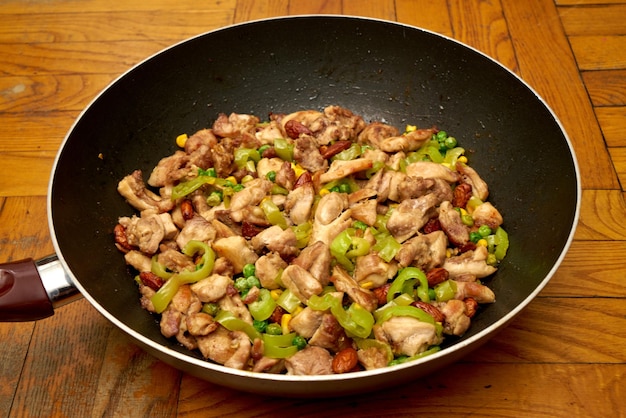 Il cinese tradizionale frigge pollo e verdure. Frittura di pollo.