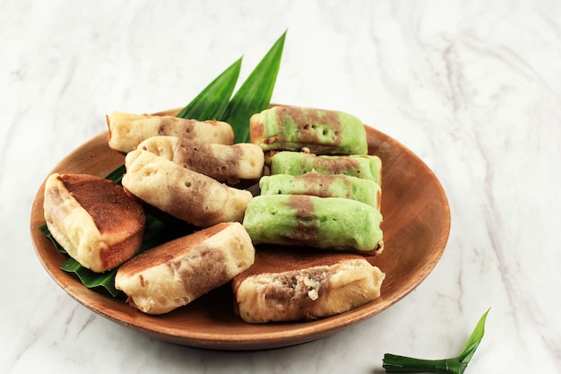 Il cioccolato Pukis Pandan è uno spuntino tradizionale popolare in Indonesia o Jajan Pasar. Questo snack è una variante di Jajanan Pasar. Copia spazio su sfondo bianco per ricetta, testo o pubblicità