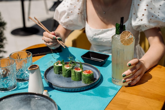 Il cliente del ristorante sta mangiando un involtini di sushi Primo piano