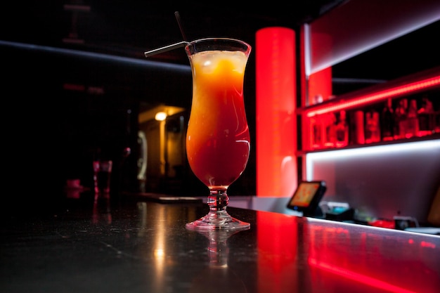 Il cocktail alcolico all'arancia è al bar. Bicchiere di cocktail su sfondo bar. Cocktail fresco con arancia e ghiaccio. Bevande alcoliche e analcoliche al bancone del bar del night club.