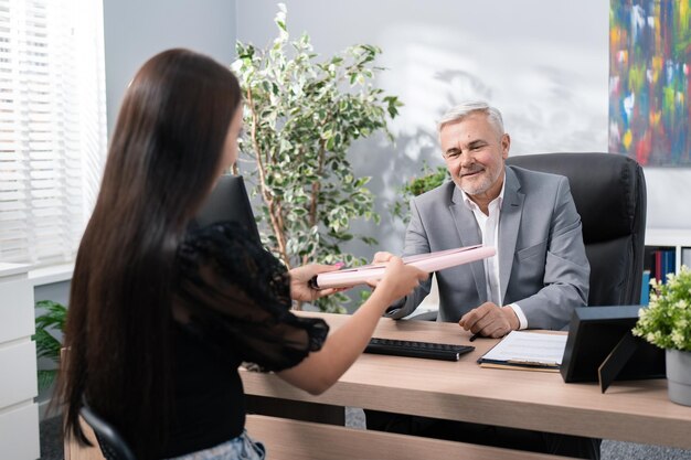 Il colloquio di lavoro nell'ufficio del capo dell'azienda è comodamente seduto dietro la scrivania in poltrona