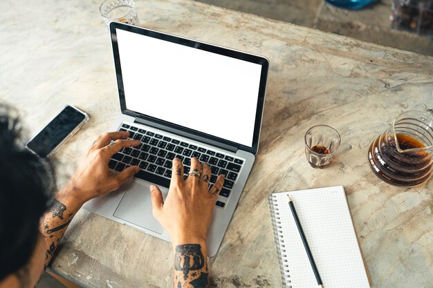 Il computer e le mani stanno lavorando sul tavolo con il caffè