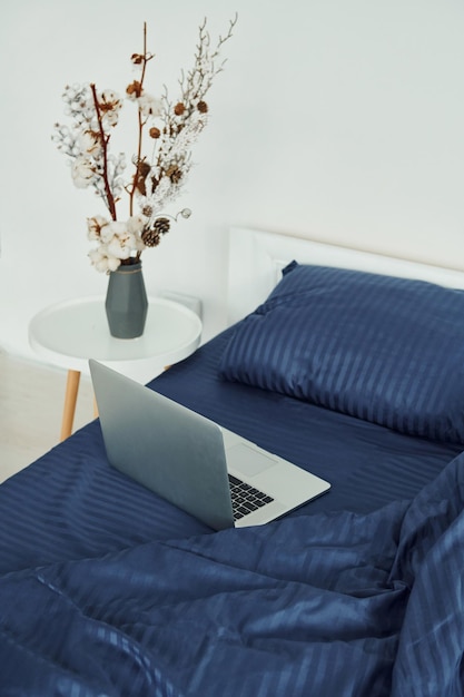 Il computer portatile è sul letto Interni e design di una bella camera da letto moderna durante il giorno