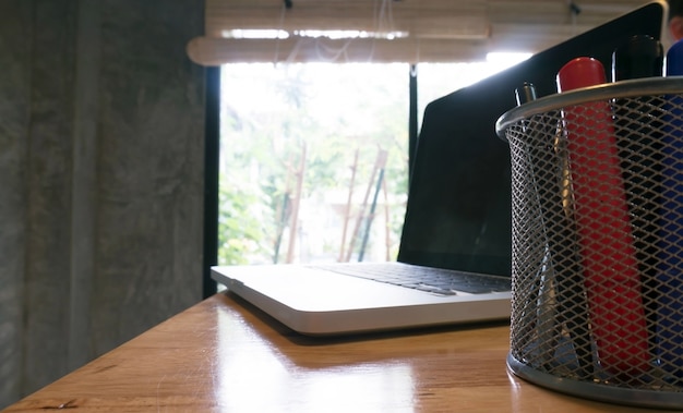 Il computer portatile si trova su un tavolo di legno.