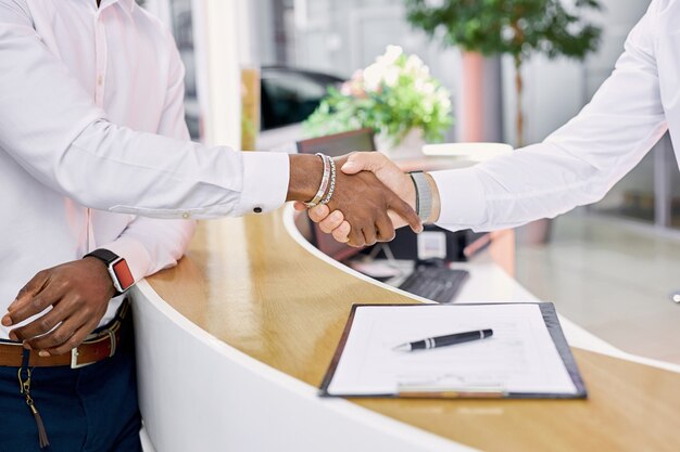 Il concessionario e il cliente di auto si stringono la mano