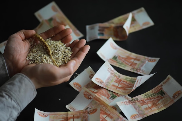 Il concetto del costo del grano Banconote da 5000 rubli intorno a una manciata di grano macinato Fame nel mondo