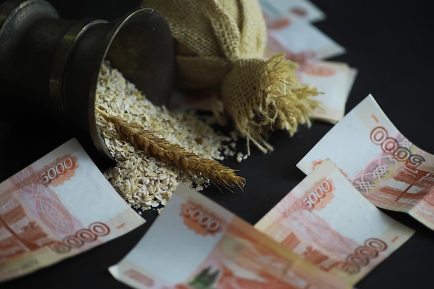 Il concetto del costo del grano Banconote da 5000 rubli intorno a una manciata di grano macinato Fame nel mondo