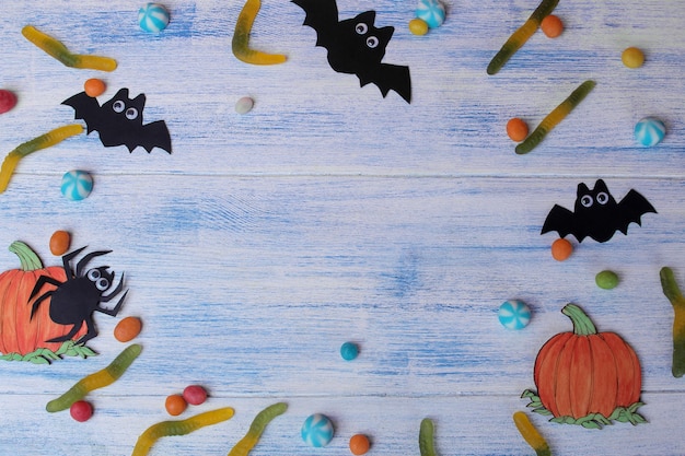 Il concetto della festa di Halloween. pipistrelli e dolci su sfondo blu con un'iscrizione dolcetto o scherzetto vista dall'alto