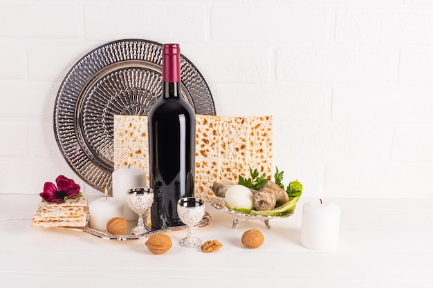 Il concetto della Pasqua ebraica Il tradizionale cibo kosher per la festa Fiori in un vaso Una candela accesa Vista anteriore