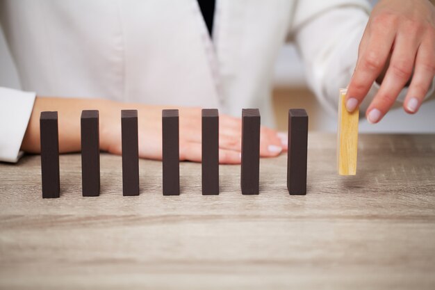 Il concetto di affari, alto vicino della donna compone i cubi di legno