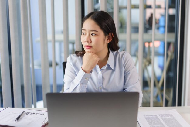 Il concetto di business La donna d'affari si siede a riflettere sul nuovo progetto mentre guarda fuori dalla finestra