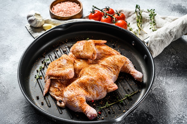 Il concetto di cucinare un pollo al tabacco. Sfondo grigio. Vista dall'alto