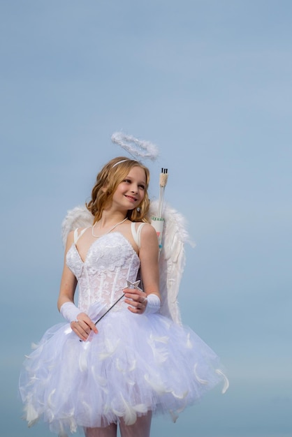 Il concetto di dio dell'amore di San Valentino ragazza vestita come un angelo su sfondo chiaro ragazza del bambino