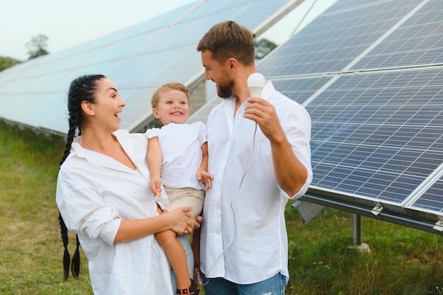 Il concetto di energia rinnovabile Giovane famiglia felice vicino ai pannelli solari