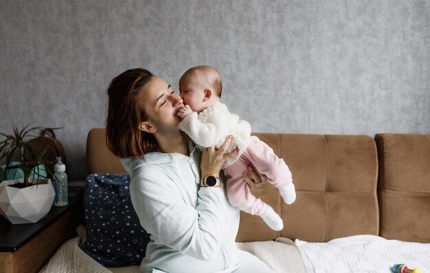 Il concetto di famiglia, una giovane madre felice con un bambino piccolo a casa, mamma e bambino