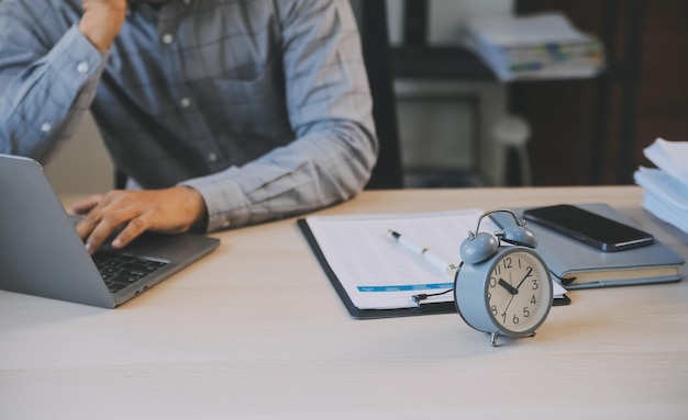 Il concetto di orari di lavoro aziendale le persone lavorano digitando sul computer portatile sovrapposto con l'orologio in tempo fino alla pausa pranzo