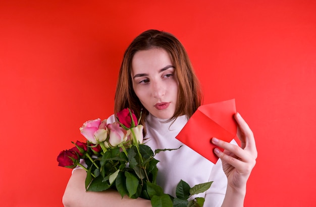 Il concetto di San Valentino e Festa della donna. Ragazza felice che tiene un mazzo delle rose