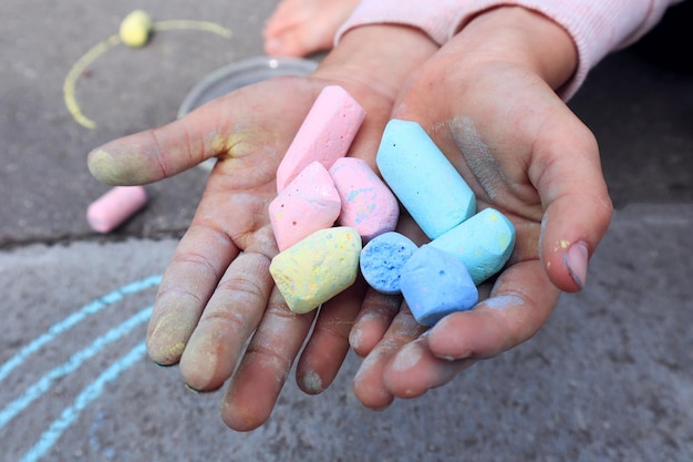 Il concetto di sviluppo della creatività nei bambini Gesso colorato per disegnare in primo piano le mani dei bambini