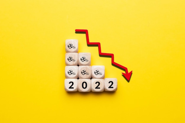 Il concetto di una crisi economica nell'anno in corso 2022 Cubi con icone di denaro e una freccia verso il basso