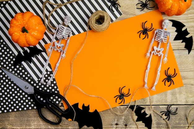 Il concetto di una felice vacanza di Halloween. Decorazioni di Halloween, pipistrelli, uno scheletro su uno sfondo arancione.