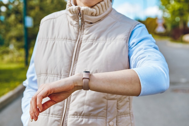 Il concetto di utilizzo di bracciali intelligenti fitness sulla mano della ragazza