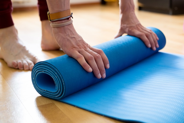 Il concetto di yoga e fitness mat nelle mani.