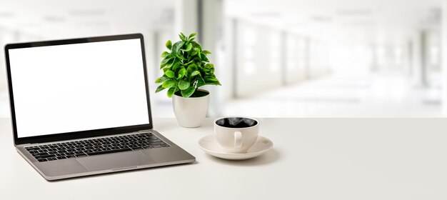 Il concetto per la tecnologia aziendale web design programmatore xABlank schermo bianco laptop tazza da caffè e vaso sono posizionati su una scrivania bianca in ufficio Close up selettiva messa a fuoco sfocato sfondo