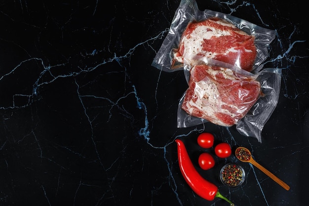 Il condimento e la carne sono confezionati sottovuoto su sfondo nero