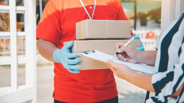 Il consumatore sta firmando un documento per ricevere un pacco da un corriere a domicilio.