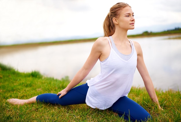 Il corpo realizza ciò in cui crede la mente Inquadratura di una giovane donna che fa yoga all'aperto