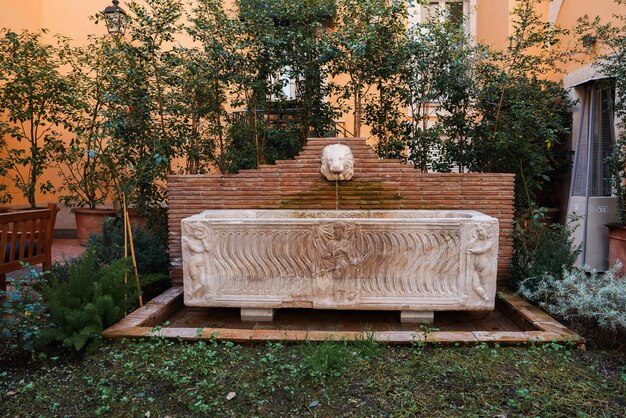 Il cortile di un hotel di lusso con la classica fontana in pietra di Roma