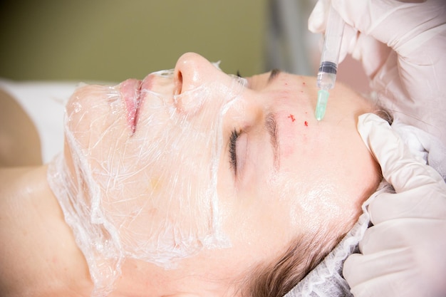 Il cosmetologo che lavora con i clienti affronta la procedura cosmetica della mesoterapia facendo iniezioni